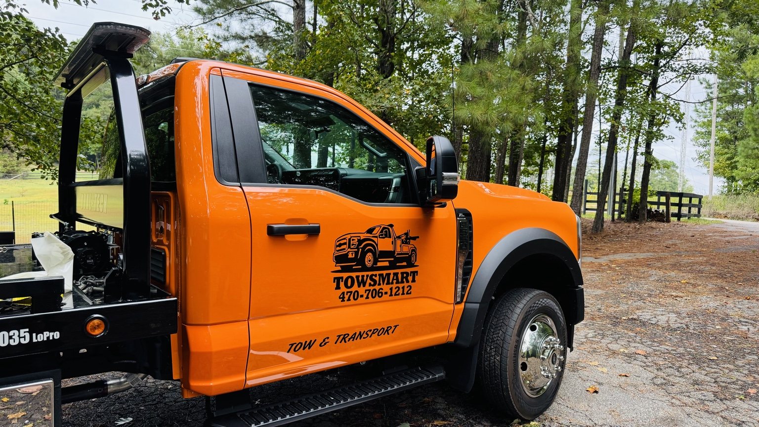 TowSmart orange flatbed tow truck with TowSmart branding